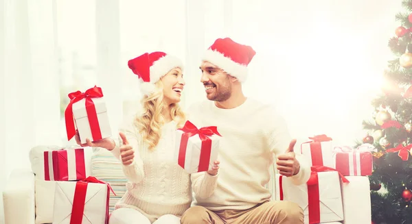 Feliz pareja con regalos de Navidad y pulgares hacia arriba —  Fotos de Stock