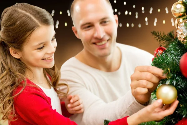 Glückliche Familie schmückt Weihnachtsbaum zu Hause — Stockfoto