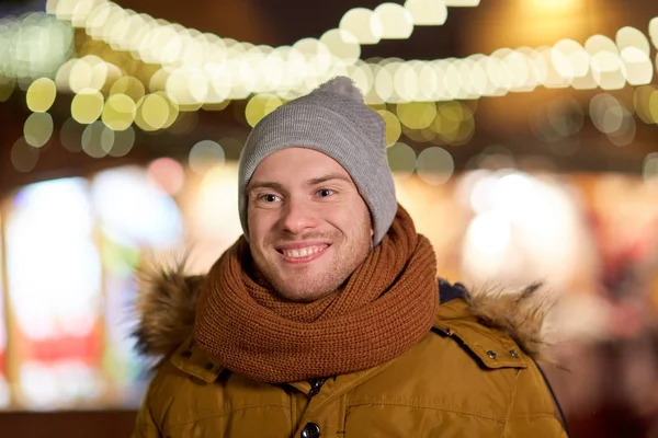 Heureux jeune homme sur les lumières de Noël en hiver — Photo