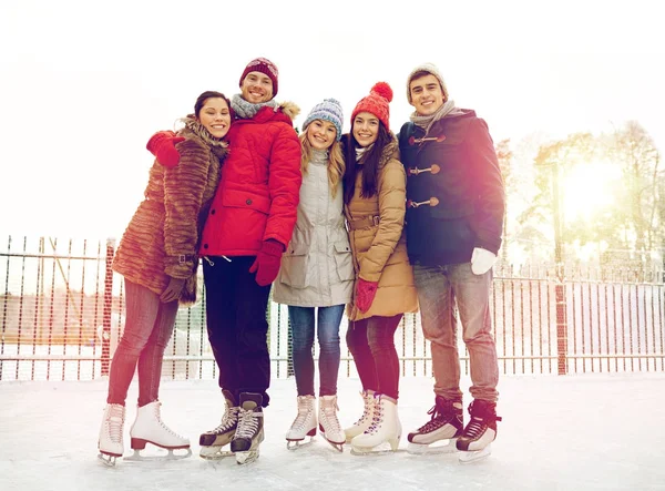 Happy friends ice skating on rink outdoors — Stock Photo, Image