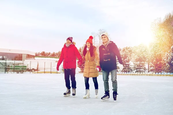 Amis heureux patinage sur la patinoire à l'extérieur — Photo