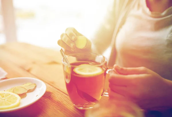 Közelkép a nő hozzá gyömbér tea citrommal — Stock Fotó