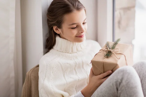 Mädchen mit Weihnachtsgeschenk sitzt zu Hause — Stockfoto