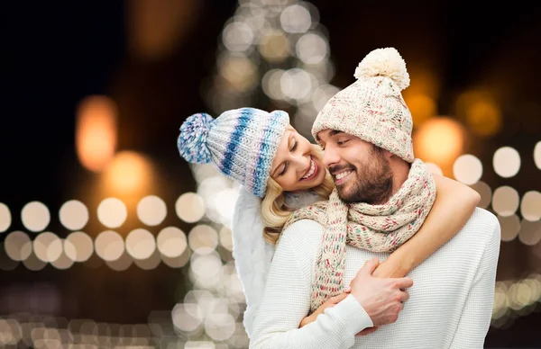 Feliz pareja abrazándose a través de luces de Navidad —  Fotos de Stock