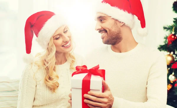 Szczęśliwa para w domu z Boże Narodzenie podatek od darowizn pudło — Zdjęcie stockowe