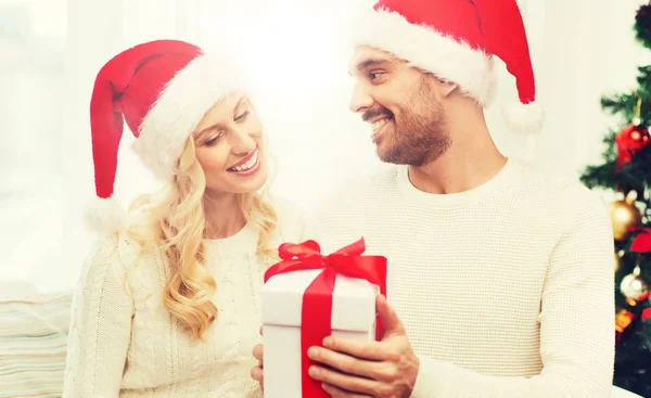 Feliz pareja en casa con caja de regalo de Navidad —  Fotos de Stock