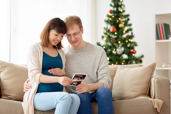 Feliz pareja con imágenes de ultrasonido en Navidad —  Fotos de Stock