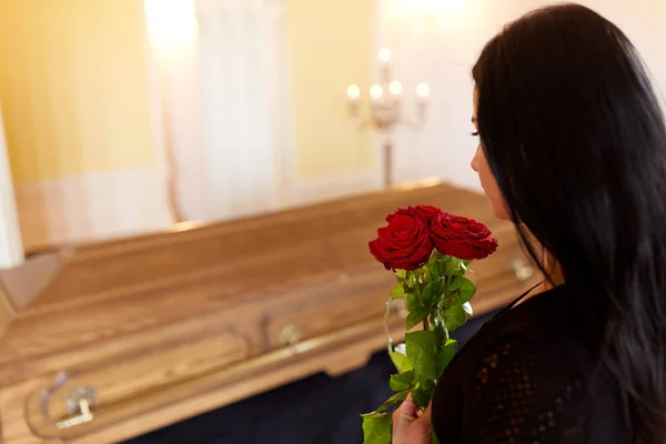 Kobieta z czerwonymi różami i trumna pogrzebowe — Zdjęcie stockowe