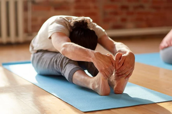 Hombre haciendo yoga hacia adelante curva en el estudio o gimnasio —  Fotos de Stock