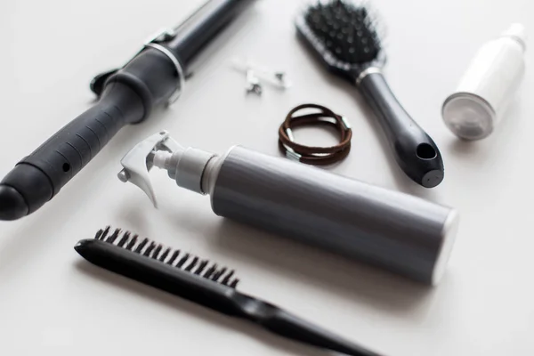 Spay estilo, escovas, laços de cabelo e ferro de ondulação — Fotografia de Stock