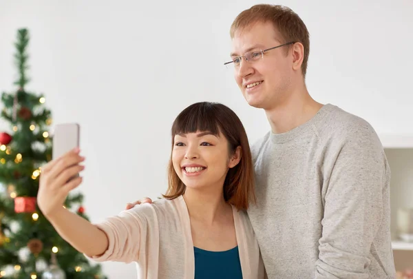 Casal misto tomando selfie no Natal — Fotografia de Stock