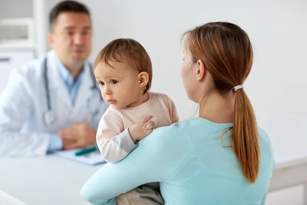 Happy woman with baby and doctor at clinic Royalty Free Stock Photos