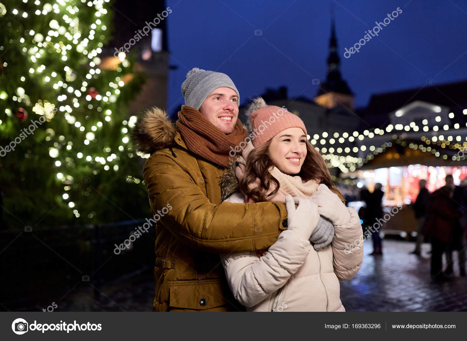 幸せなカップルのクリスマス ツリーでハグ ストック写真 C Syda Productions