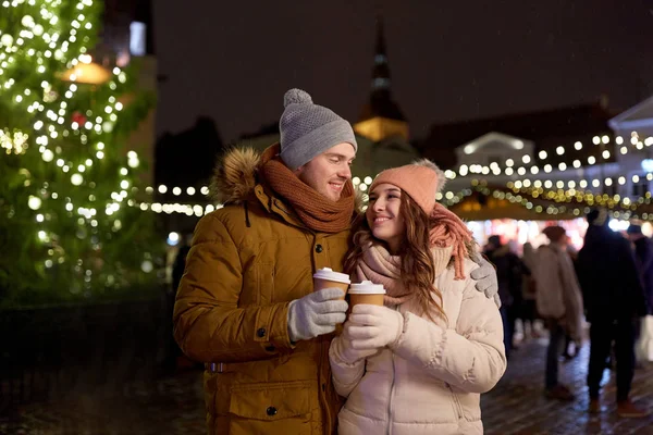 Gelukkige jonge paar met koffie op kerstmarkt — Stockfoto