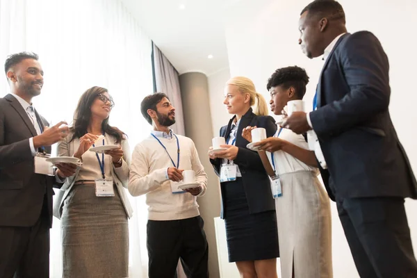 Affärsfolk med konferensen märken och kaffe — Stockfoto