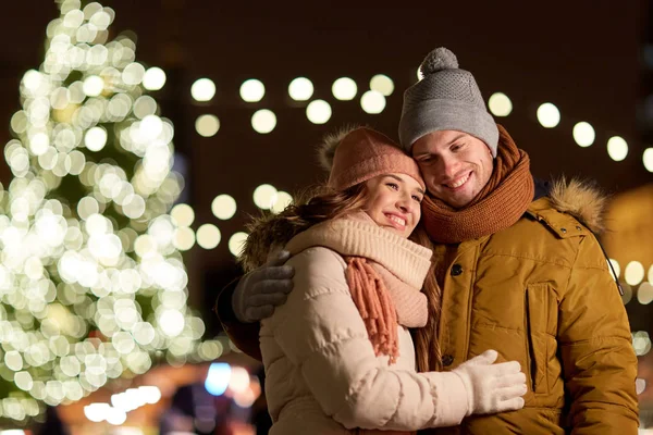 Feliz pareja abrazándose en el árbol de Navidad —  Fotos de Stock