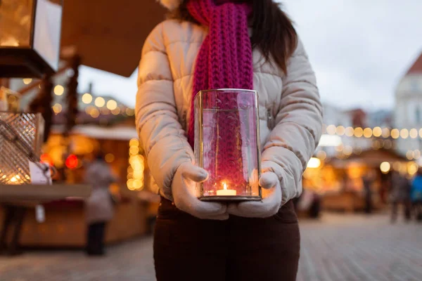 Женщина со свечой в фонаре на рождественском рынке — стоковое фото