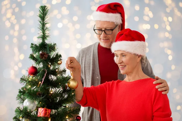 Happy senior couple decorating christmas tree — Stock Photo, Image