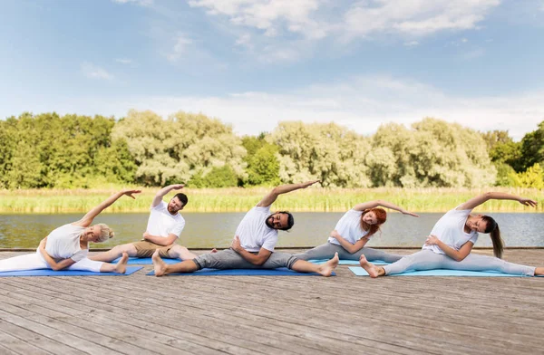 Group of people making yoga exercises outdoors — Stock Photo, Image