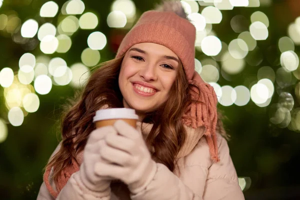 Mujer feliz con café sobre luces de Navidad —  Fotos de Stock
