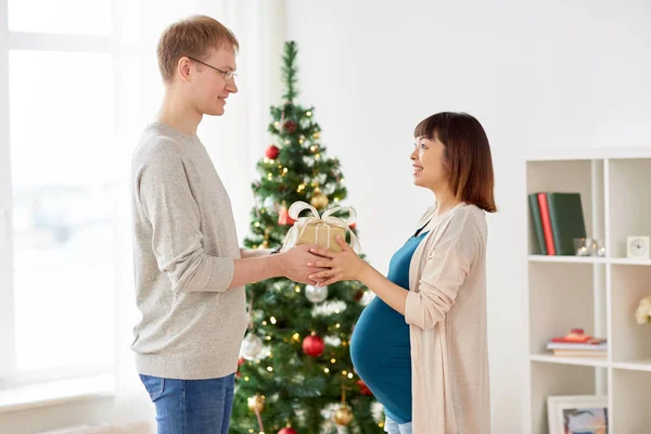 Marito dando regalo di Natale alla moglie incinta — Foto Stock
