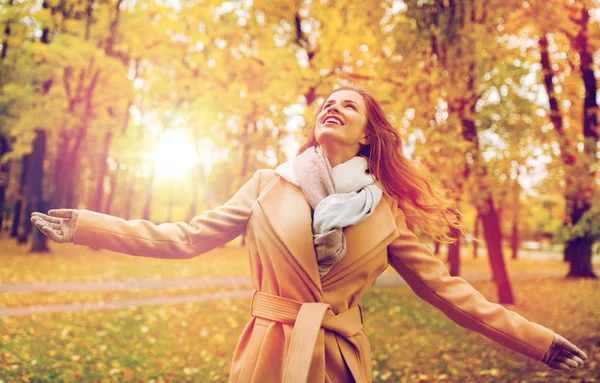 Schöne glückliche junge Frau, die im herbstlichen Park spaziert — Stockfoto