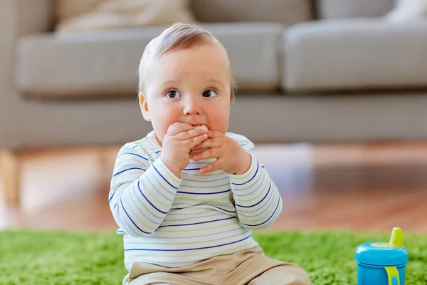 Bebé en el suelo y comer galleta de arroz en casa — Foto de Stock