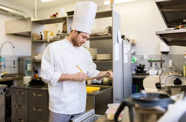 Koch mit Klemmbrett macht Inventar in der Küche — Stockfoto