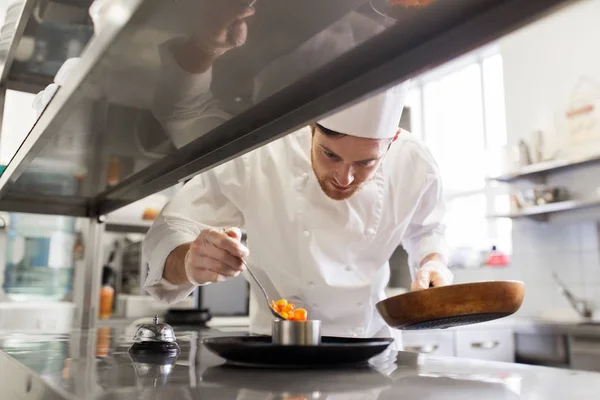 Happy male chef cooking food at restaurant kitchen — Stock Photo, Image