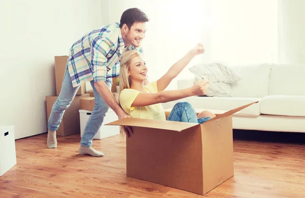 Feliz pareja divirtiéndose con cajas en nuevo hogar —  Fotos de Stock