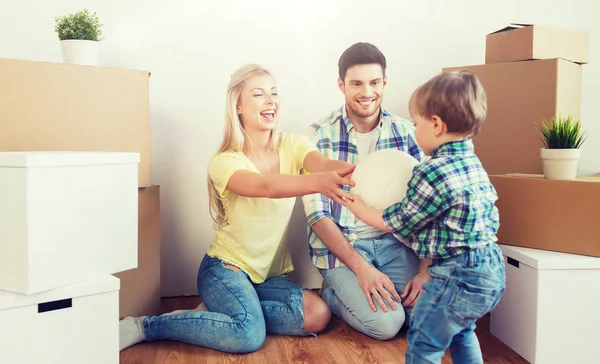 Familia feliz mudándose a un nuevo hogar y jugando pelota — Foto de Stock