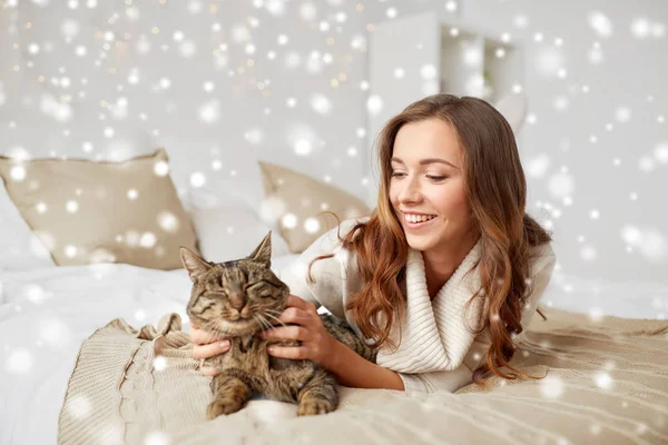 Jovem feliz com gato deitado na cama em casa — Fotografia de Stock