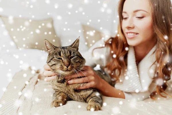 Šťastná mladá žena s kočkou, ležící v posteli doma — Stock fotografie