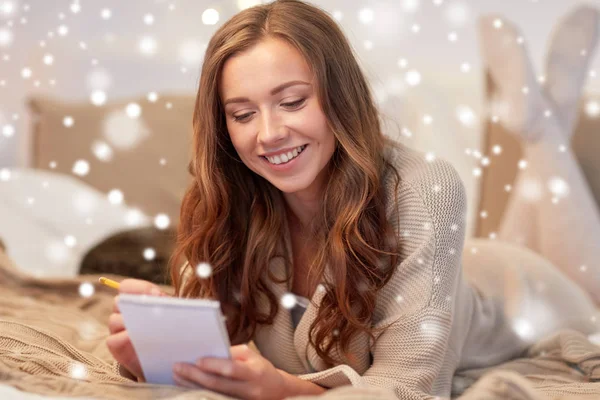 Gelukkig jonge vrouw met laptop in bed thuis — Stockfoto