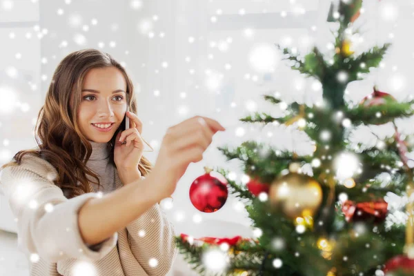 Mujer con smartphone decorando árbol de navidad —  Fotos de Stock