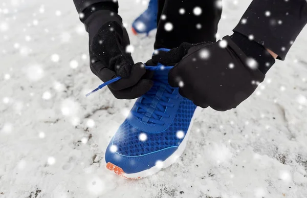 Bliska człowieka wiązanie Sznurowadło buta w zimie na zewnątrz — Zdjęcie stockowe