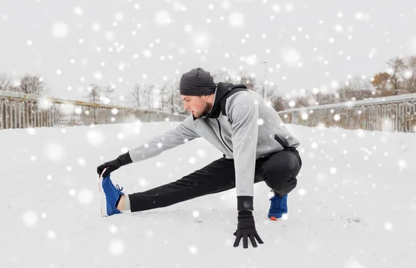 Man utövar och stretching benet på vintern bridge — Stockfoto