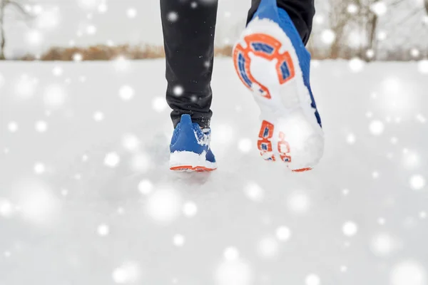 Zbliżenie stóp biegnących wzdłuż śnieżnej zimowej drogi — Zdjęcie stockowe