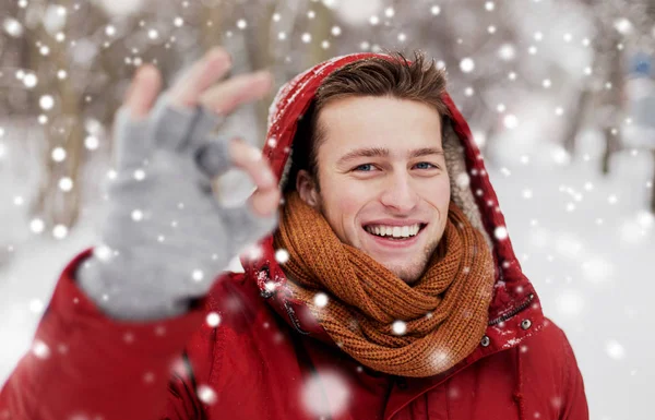 Szczęśliwy człowiek w kurtka zimowa Wyświetlono ok ręka znak — Zdjęcie stockowe
