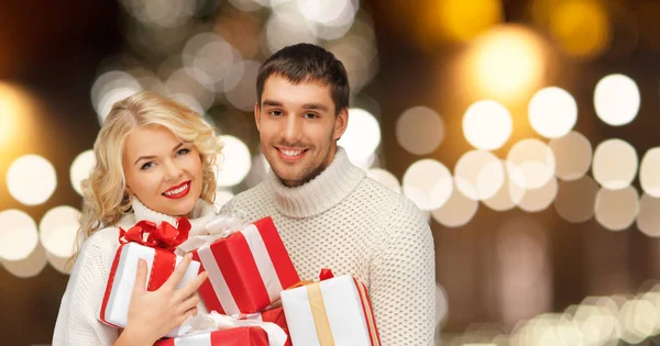 Счастливая пара в свитерах с рождественскими подарками — стоковое фото