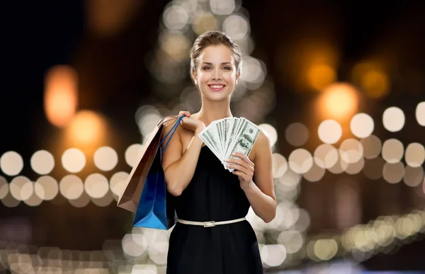 Mulher com sacos de compras e dinheiro no Natal — Fotografia de Stock