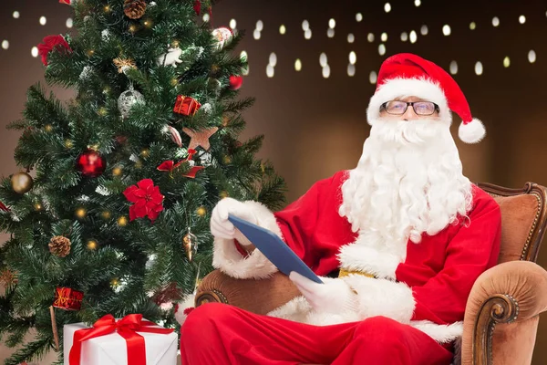 Санта-Клаус з планшетним ПК і ялинкою — стокове фото