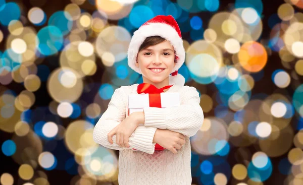 Sorrindo menino feliz em santa chapéu com presente de Natal — Fotografia de Stock