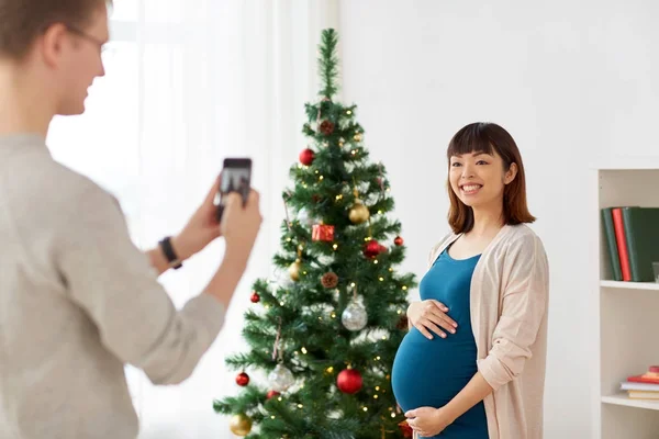 Муж фотографирует беременных на Рождество — стоковое фото