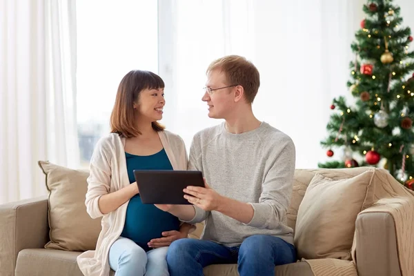 Homem e mulher grávida com tablet pc no Natal — Fotografia de Stock