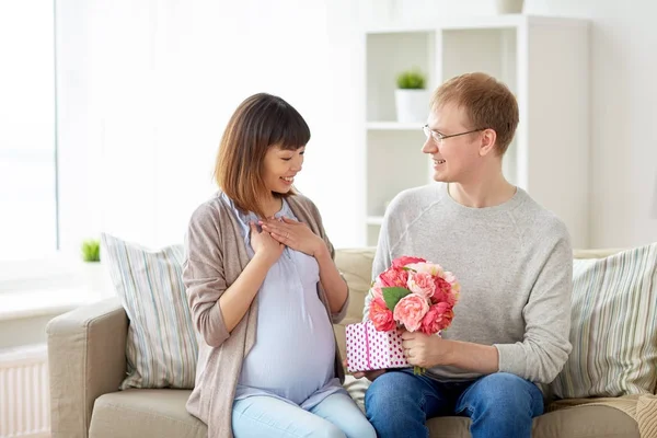 Šťastný manžel dává přítomen své těhotné ženě — Stock fotografie