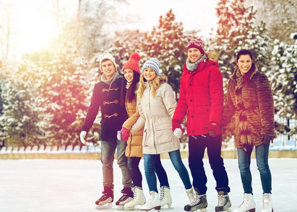Happy vrienden schaatsen op de ijsbaan buitenshuis Rechtenvrije Stockfoto's