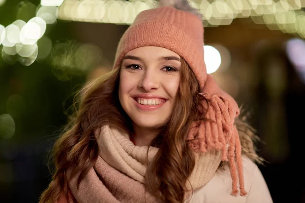 Šťastná mladá žena nad vánoční světla v zimě — Stock fotografie