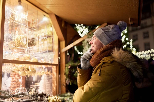 Homme heureux regardant la fenêtre du marché de Noël — Photo