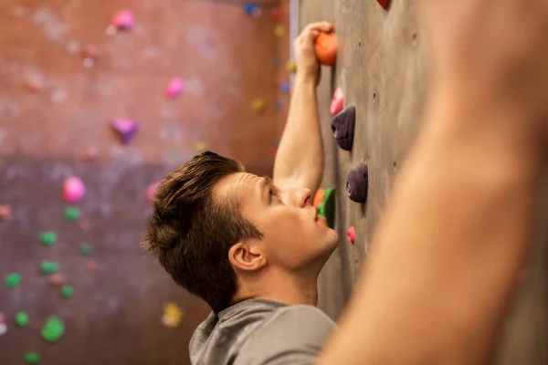 Jongeman aan het sporten in de indoor klimzaal — Stockfoto